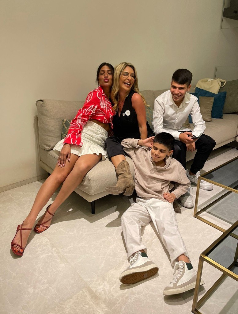 Kim Dukarker with family gathered together on the sofa, laughing and smiling