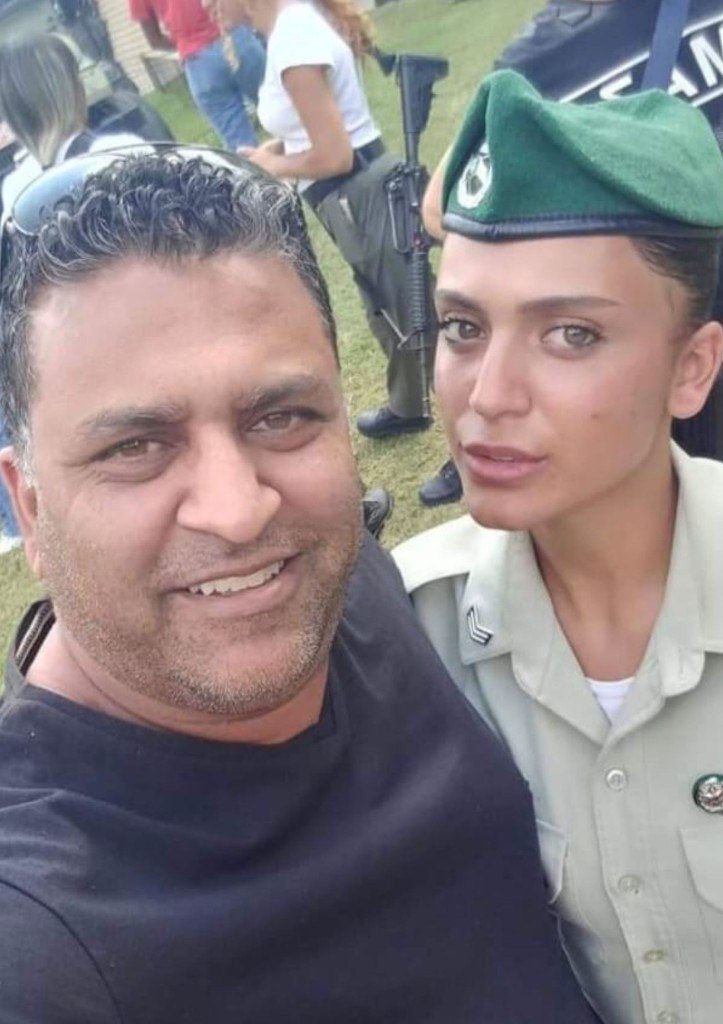 Kim in her green-bereted Border Police uniform taking a proud selfie with a smiling man at an outdoor ceremony